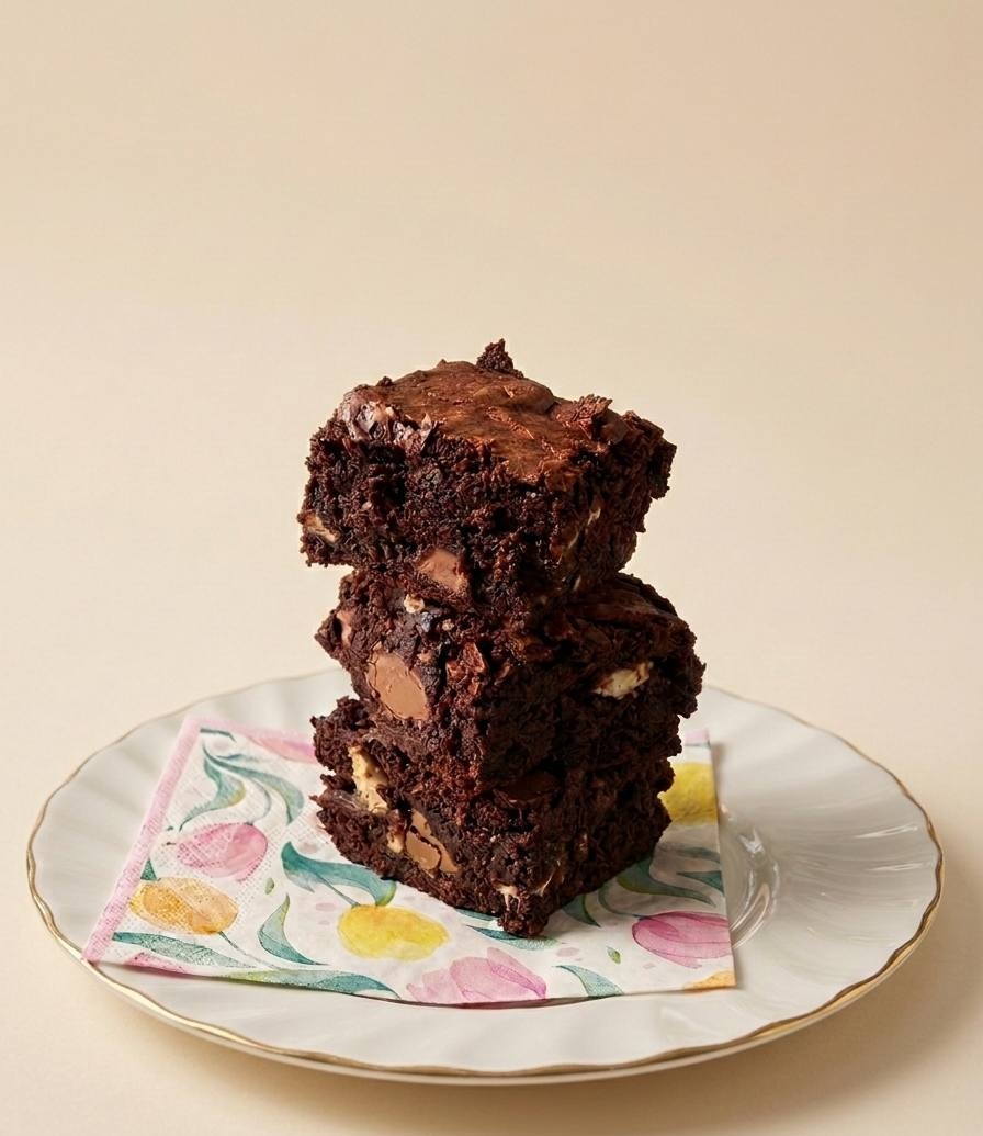 Stack of homemade brownies on a vintage floral plate
